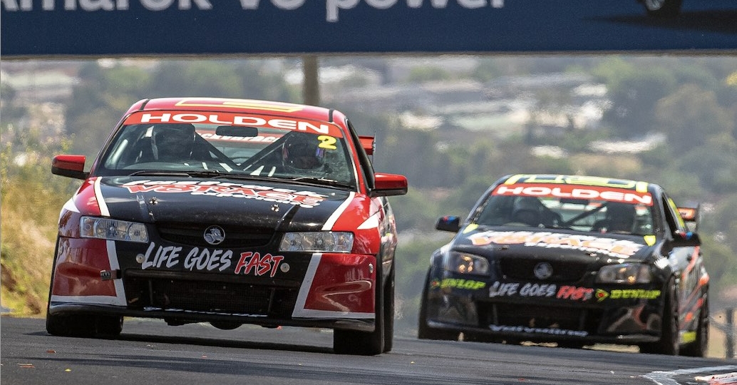 two race cars speeding along the track at bathurst