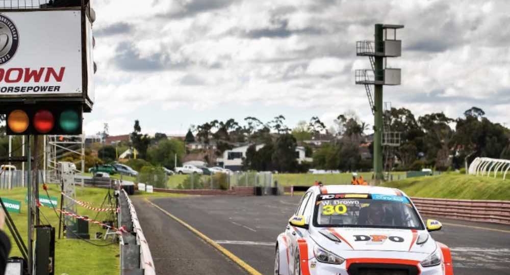 white race car crossing the finish line