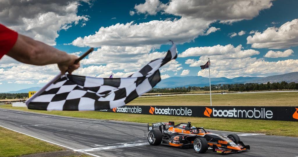 orange and black race car driving around the track australian race cars championship