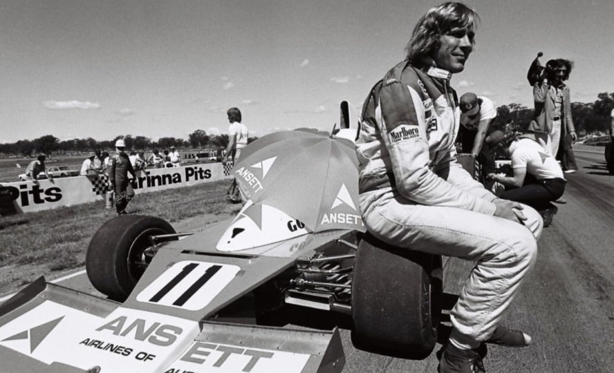 black and white photo features a driver sitting on top of a race car at winton raceway