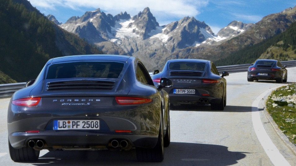 porsche driving with mountains in the background