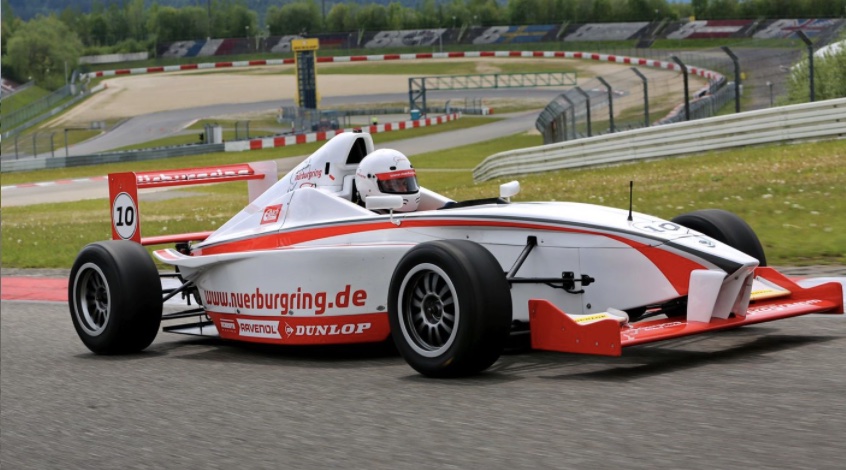 read and white formula one racing car at Nurburgring