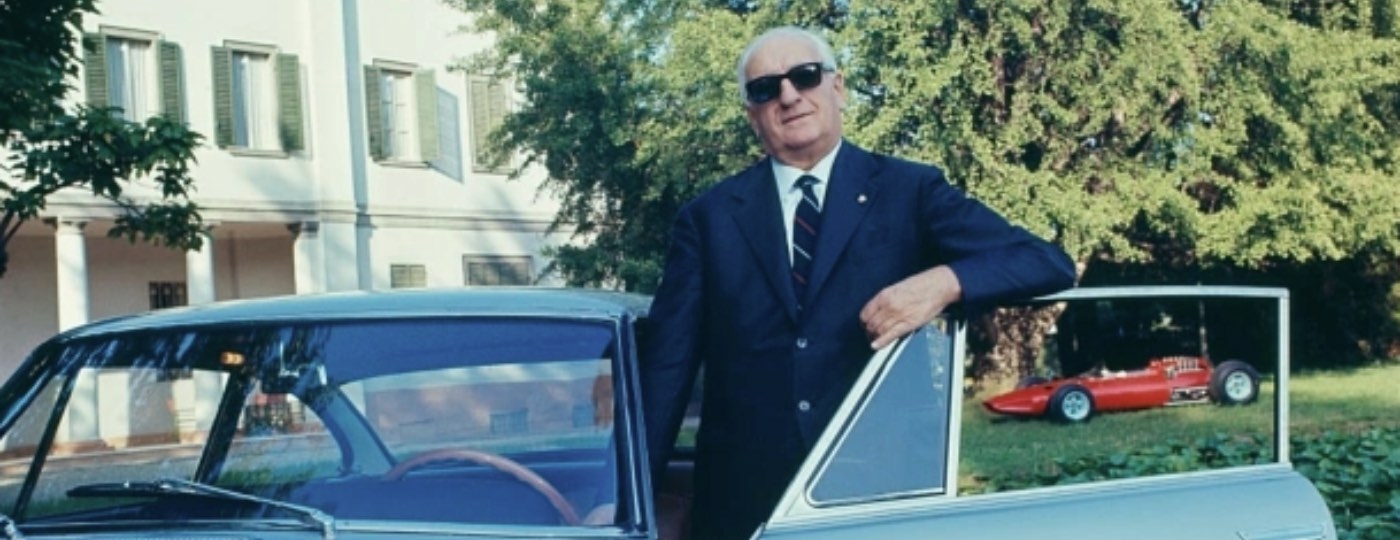 photo of enzo ferrrari standing by his car