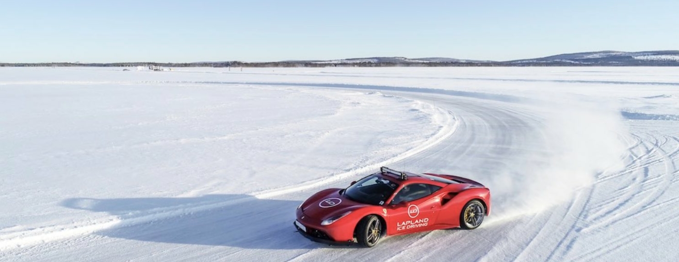 red car driving on ice lapland